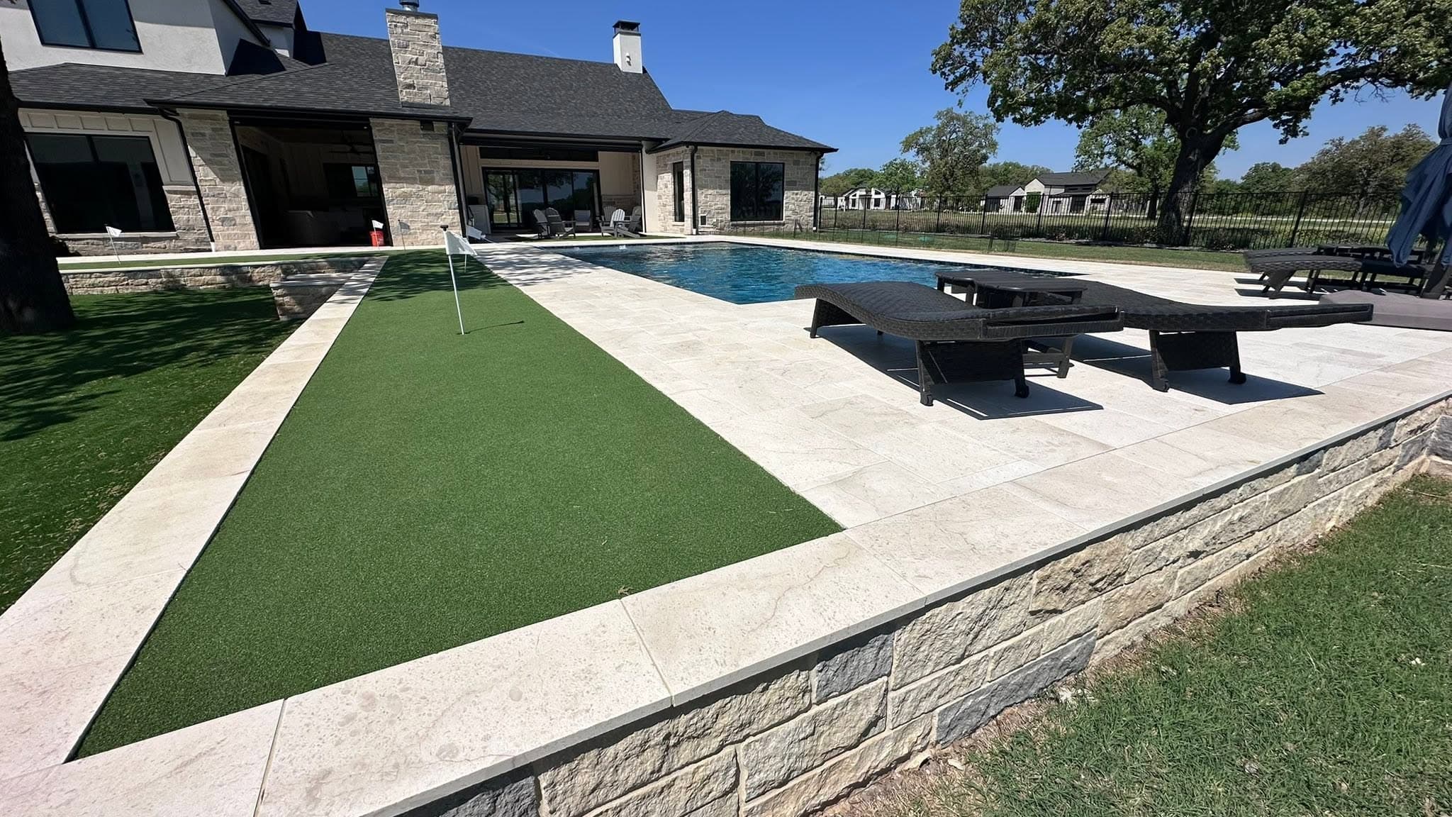 Completed pool terrace with broad patio, lawn, and room for outdoor gathering