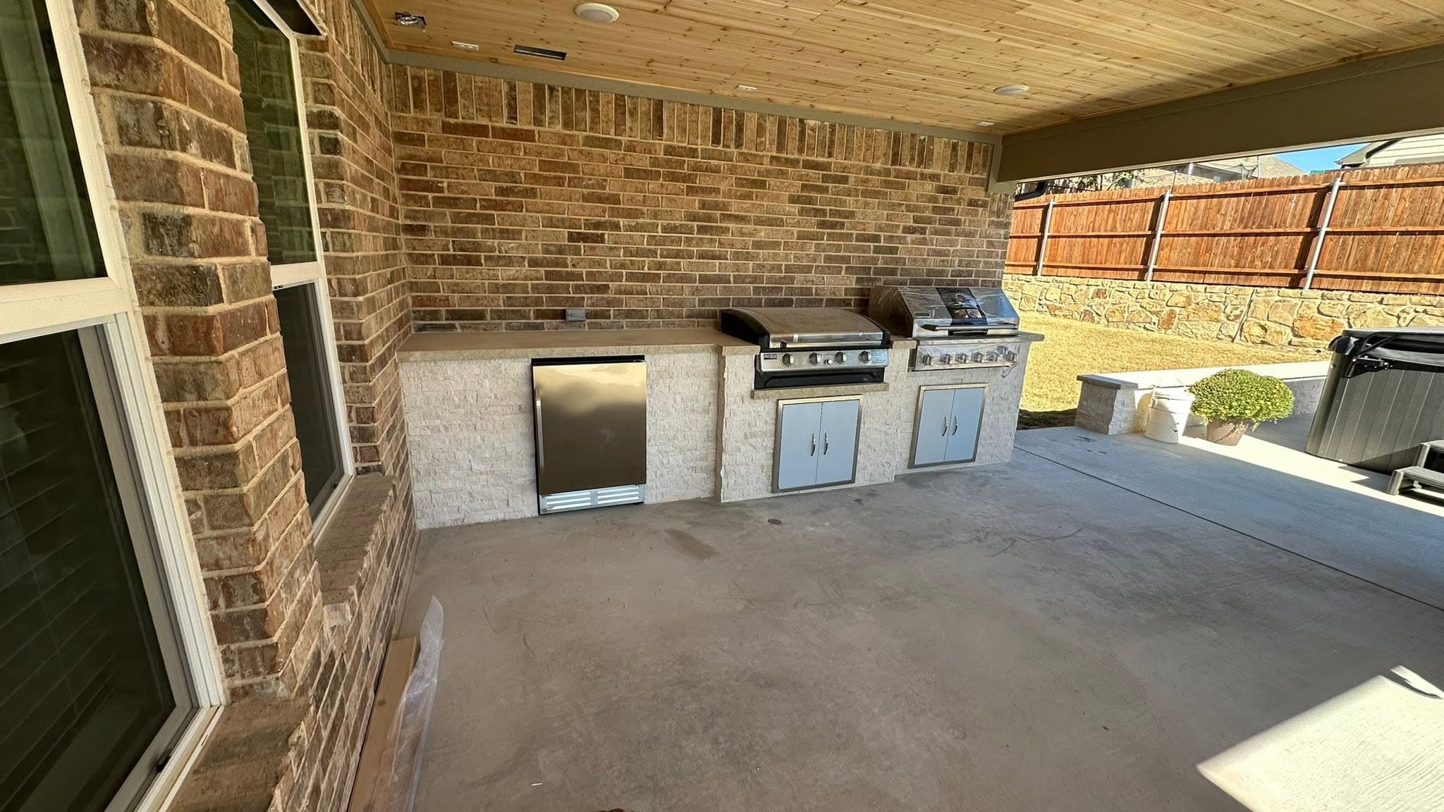 Covered outdoor kitchen finished in warm brick