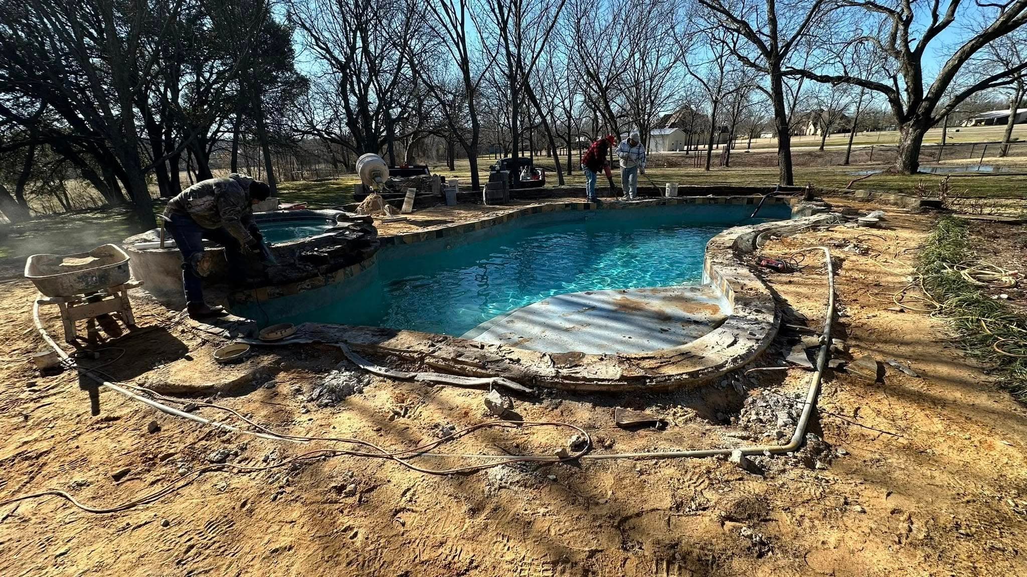 Crew working around a freeform pool during construction