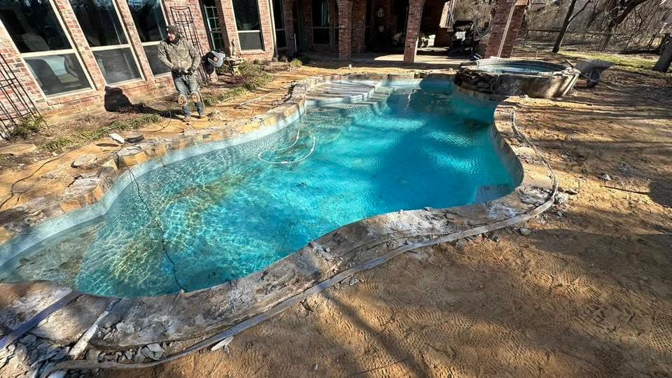 Freeform turquoise pool edged with natural stone