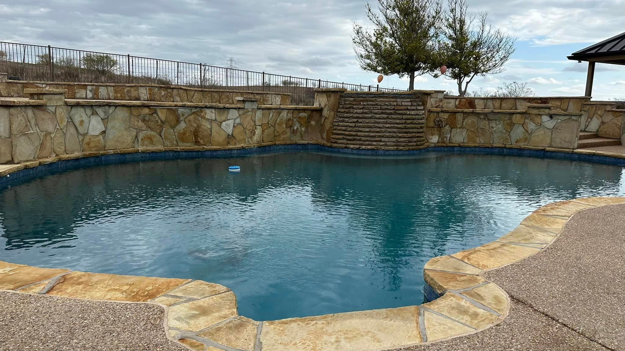 Pool water flowing from a raised stone spa