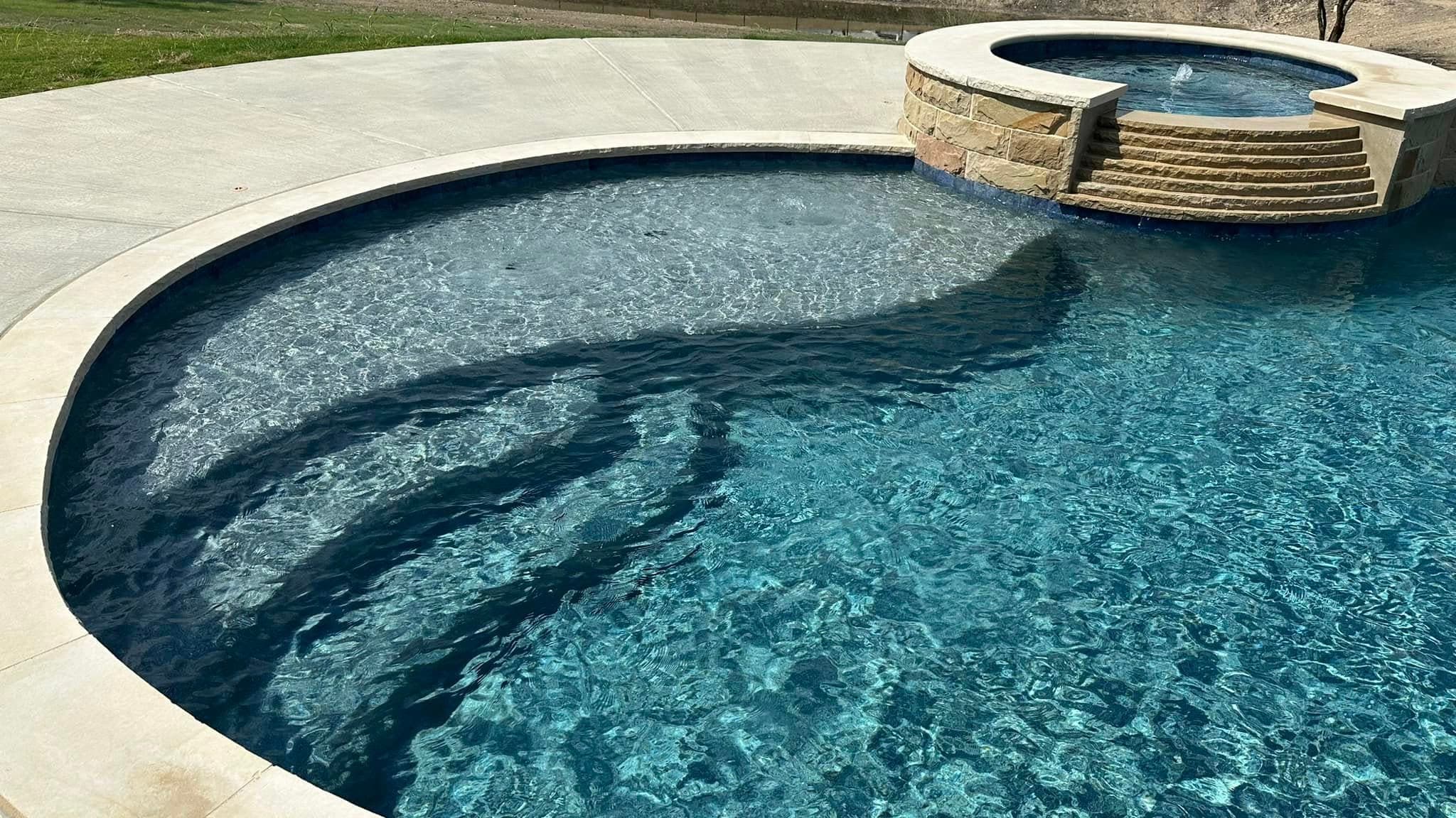Curved pool and raised spa detail with flowing water
