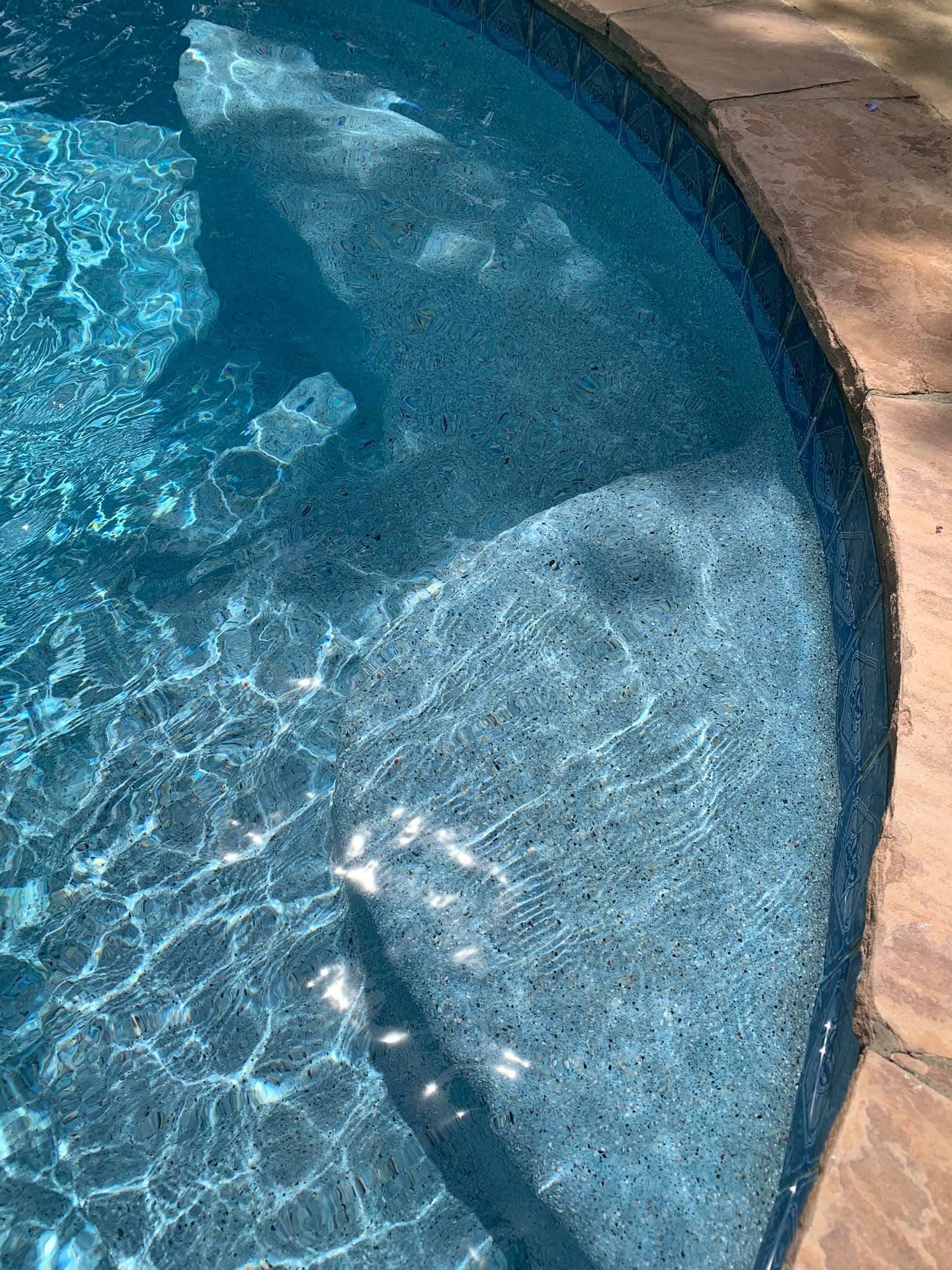 Close view of refreshed pool steps, tile, coping, and shimmering water