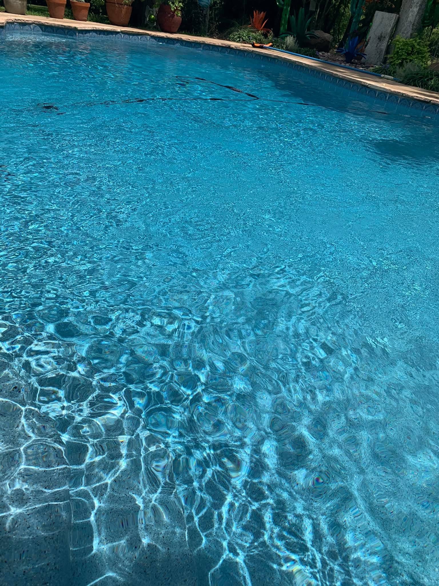 Close view of pool water, interior finish, and curved coping